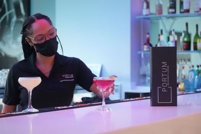 Bartender serving a cocktail in Portum Bar at Harborside Hotel