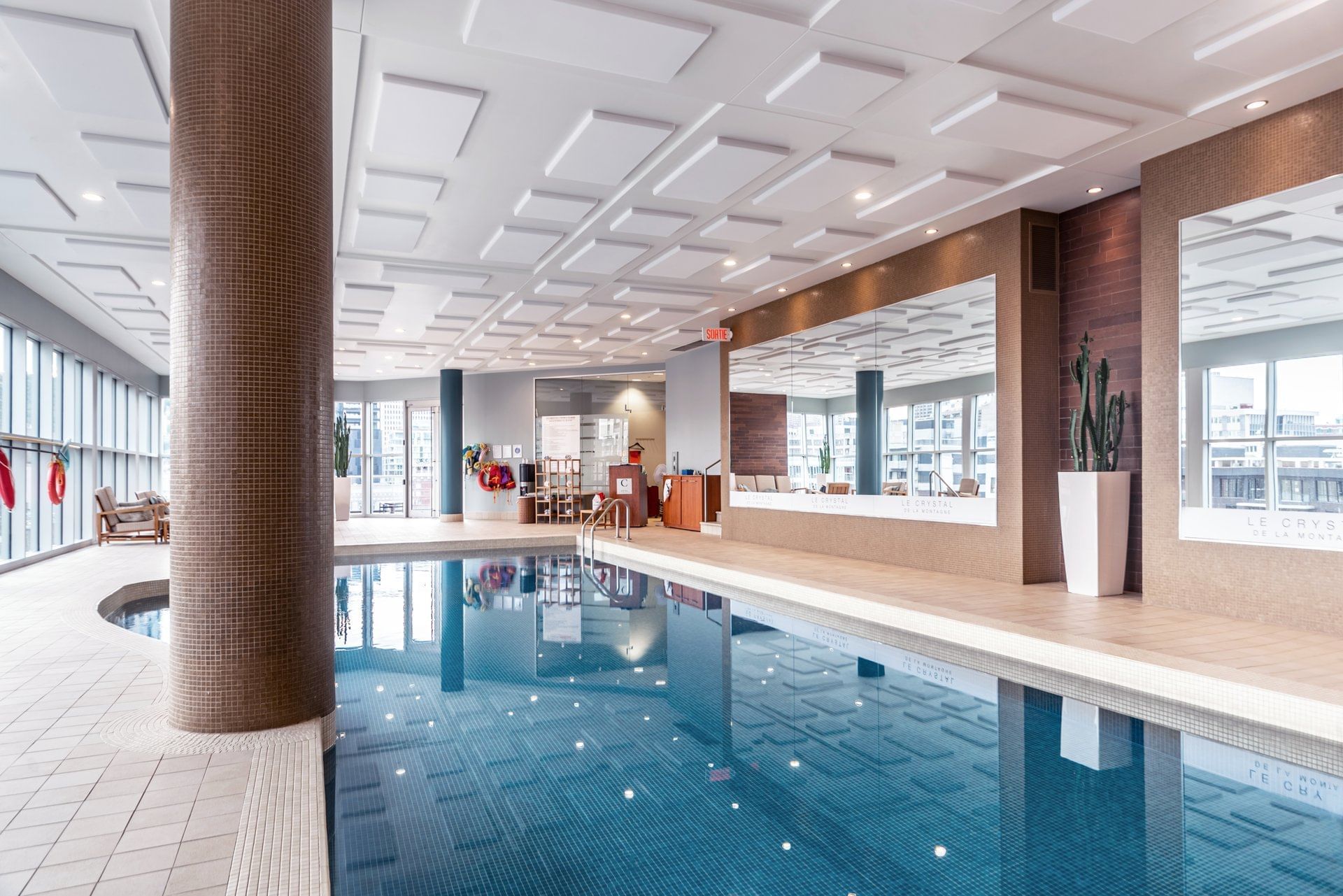 Indoor pool with lounging area at Warwick Le Crystal - Montreal