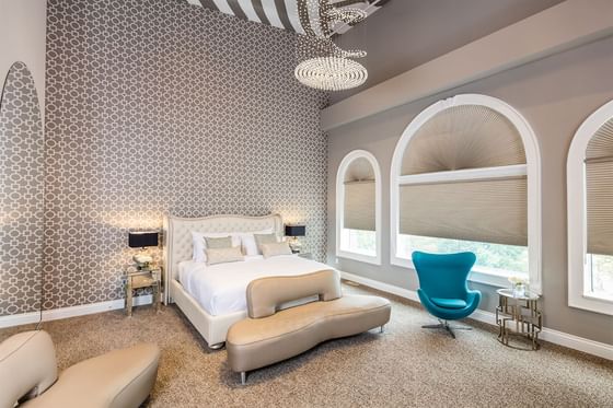 Modern furniture, chandelier & comfy bed in a Presidential Room at Retro Suites Hotel