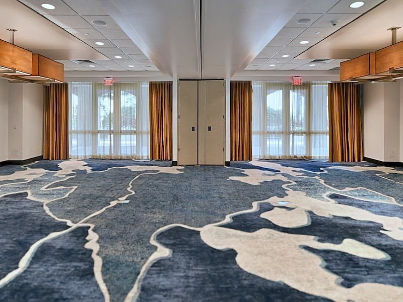Vieques meeting room with intricate carpet design, warm lighting, and large windows at El Conquistador Resort