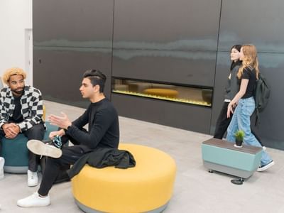 Students socializing in the Laurent lobby, with modern seating and a warm fireplace.