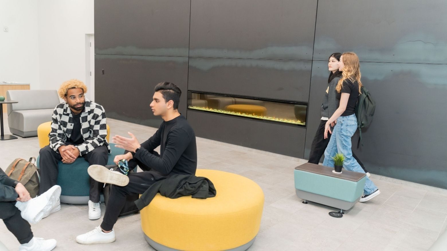 Students socializing in the Laurent lobby, with modern seating and a warm fireplace.