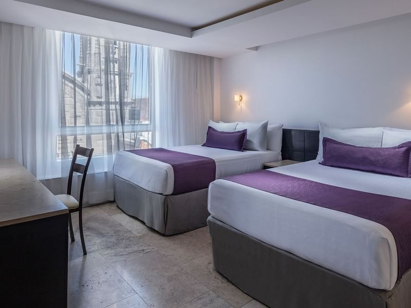 Beds by a window & work desk in Deluxe Room 2 Double at Gamma Hotels