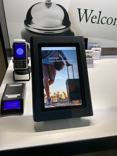 Digital welcome screen for Avaneo Hotel Marktredwitz, featuring a guest with a suitcase, showcasing hotel images