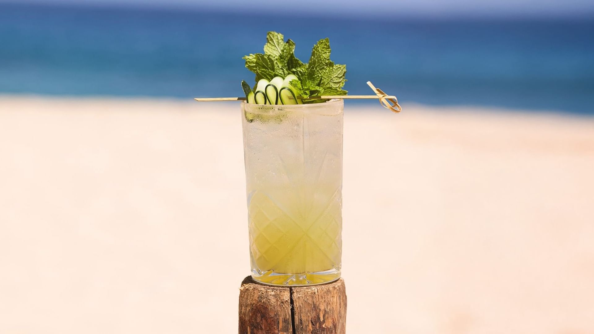 Tropical cocktail with cucumber and mint garnish on the beach at Tortugas, Hacienda Del Mar Los Cabos Redesign, Cabo San Lucas.