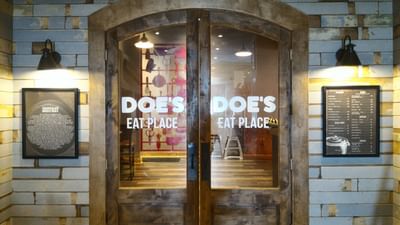 Entrance to Doe's Eat Place featuring rustic wooden doors and local history plaques at Margaritaville Resort Biloxi