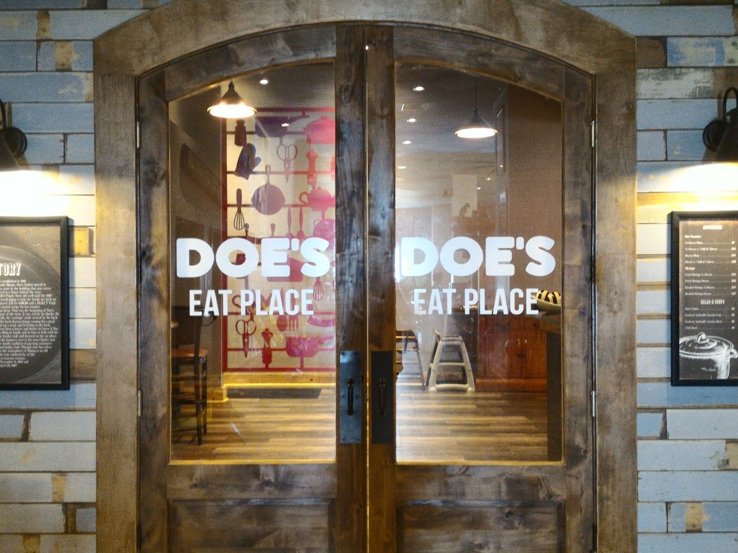 Entrance to Doe's Eat Place featuring rustic wooden doors and local history plaques at Margaritaville Resort Biloxi