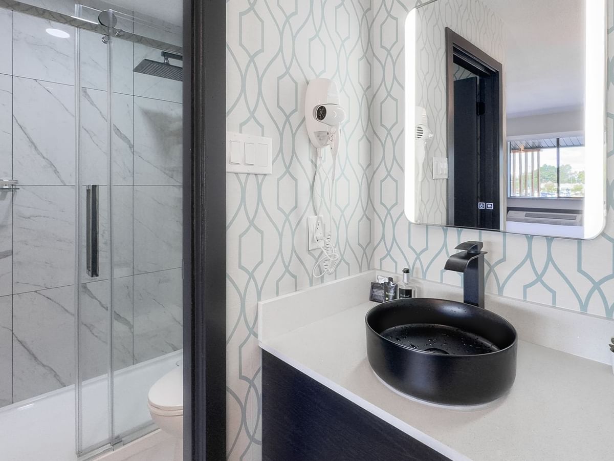 Hotel bathroom with toilet, shower, sink and soap