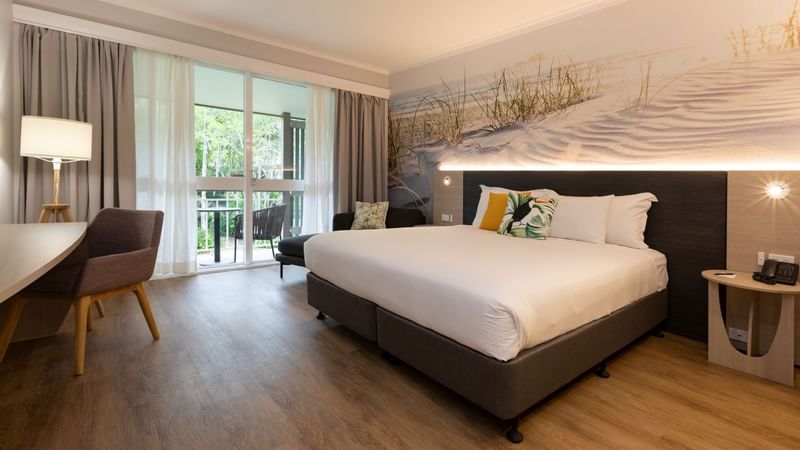 Classic room with king bed, coastal wall art, desk, balcony access, and modern furnishings at Novotel Sunshine Coast.