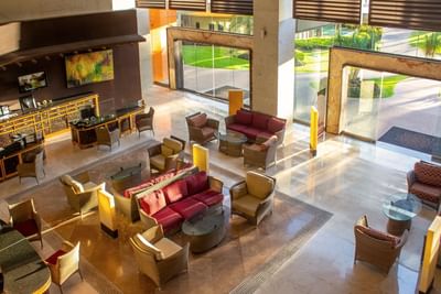 Foto del hotel Sunset Plaza Beach Resort tomada en la recepción, con sillones, ventanales grandes y decoración elegante en tonos rojizos y marrones