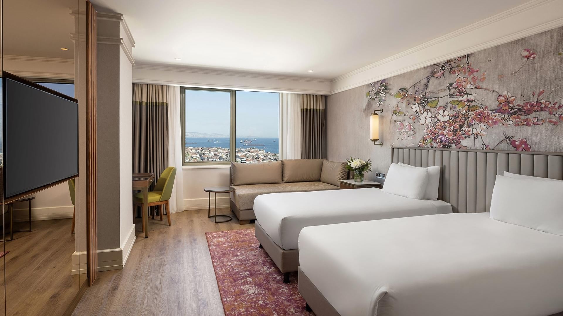 Titanic Port Bakırköy’de Deluxe Sea View Room’da ikiz yataklar, TV ve deniz manzaralı çalışma alanı.