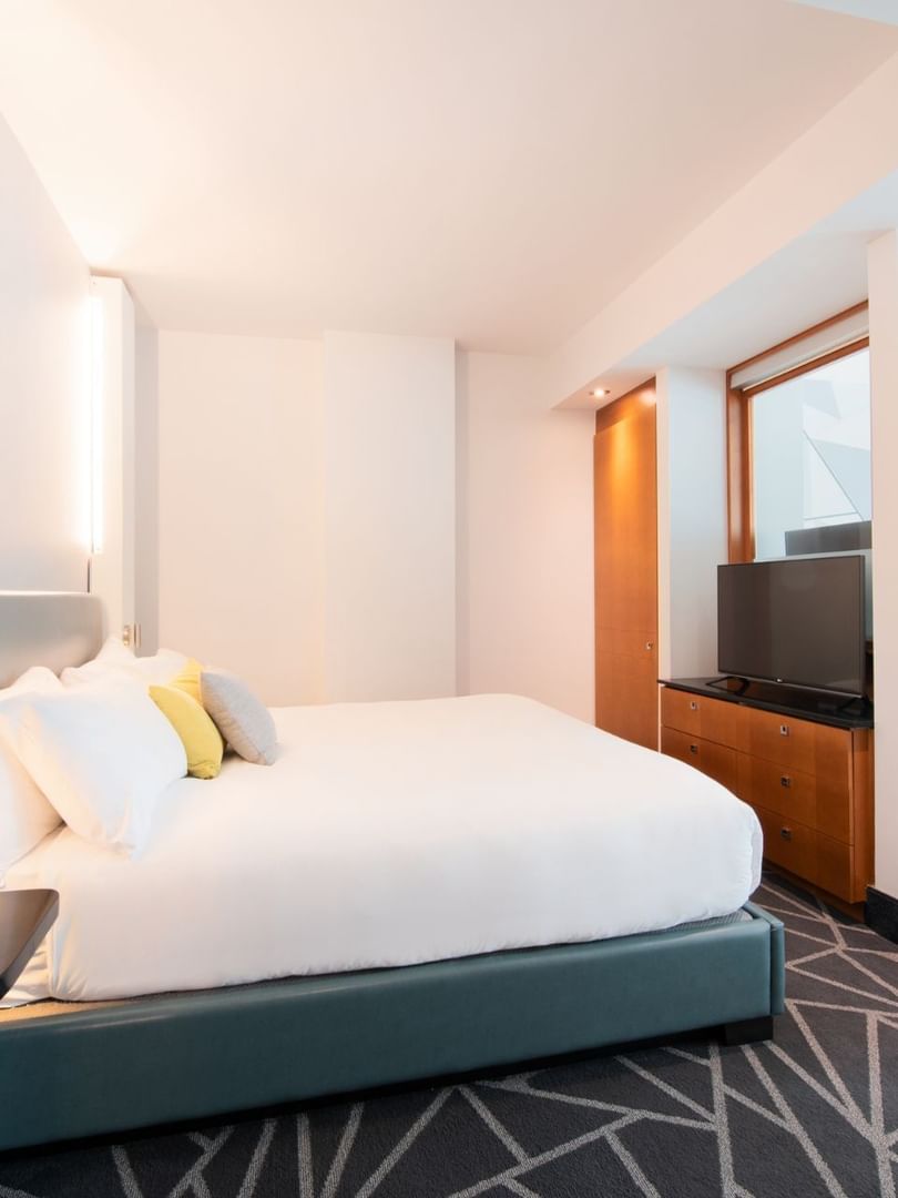 TV facing bed with separate living area in Premium loft Suite at Warwick Le Crystal Montreal