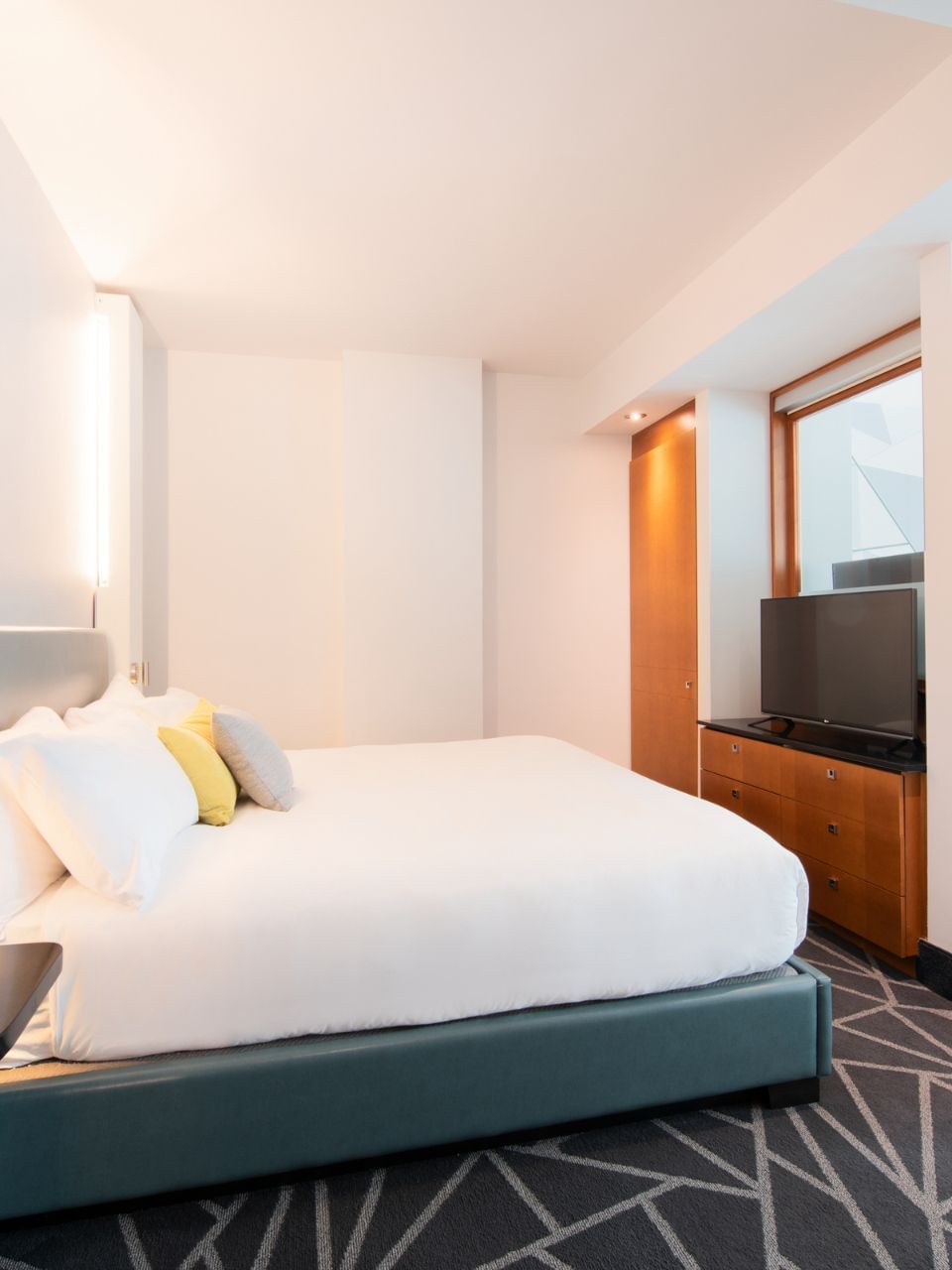 Chambre moderne avec grand lit dans la suite Premium Loft du Warwick Le Crystal