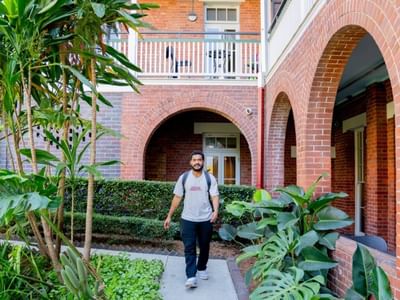 Student walking along pathway towards accommodation entrance.