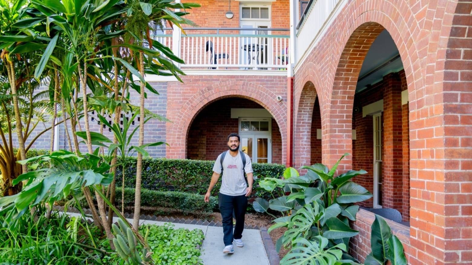 Student walking along pathway towards accommodation entrance.