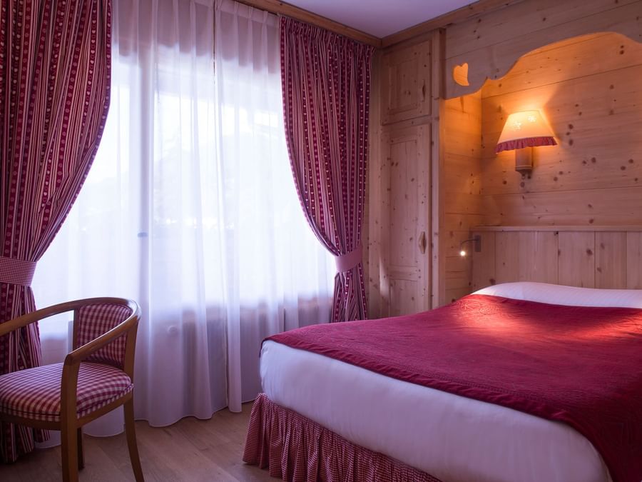 Queen bed in a room at Chalet-Hotel Neige et Roc