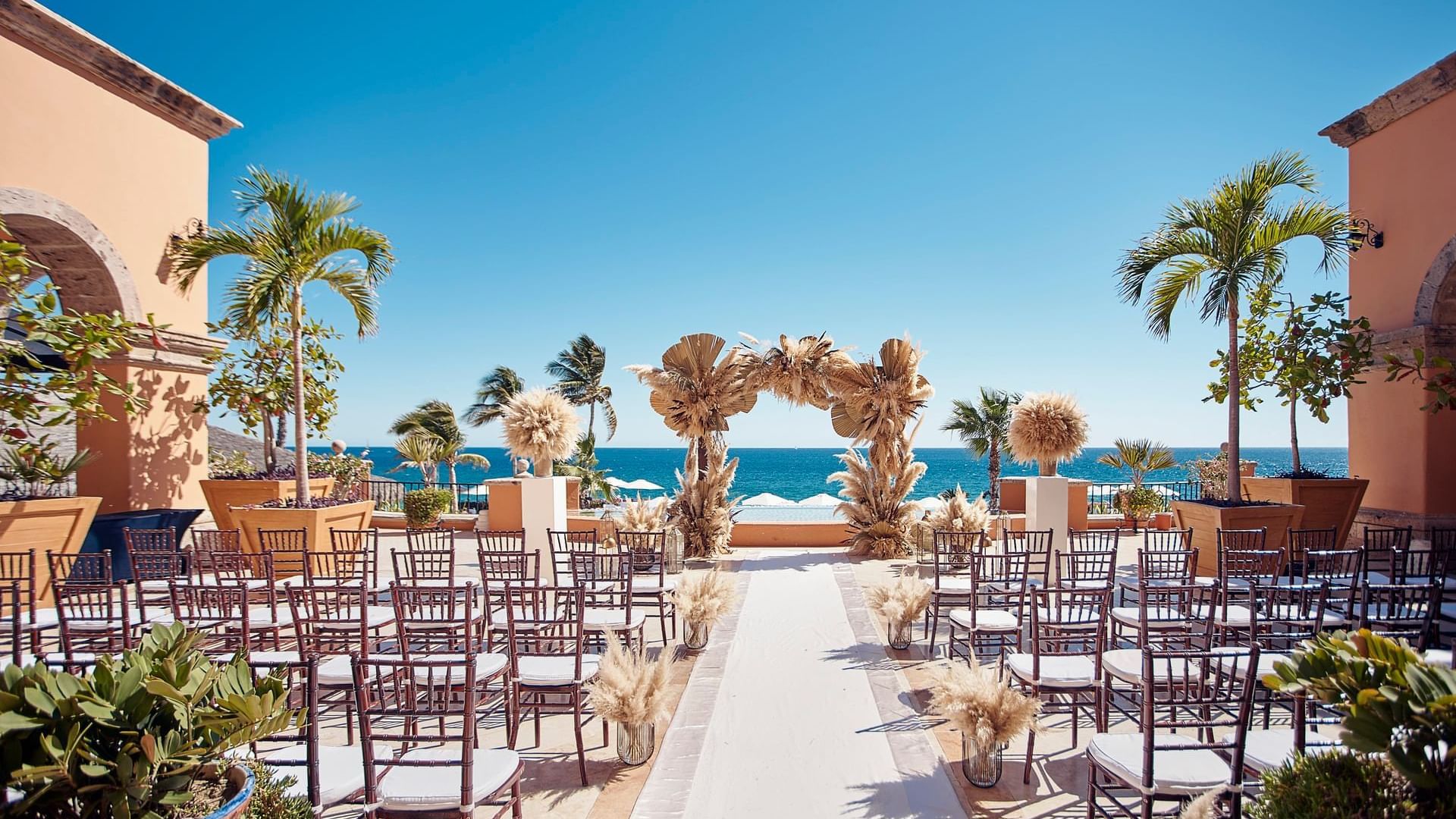Plazuela Outdoor wedding setup with chairs arranged neatly facing the ocean at Hacienda del Mar Los Cabos