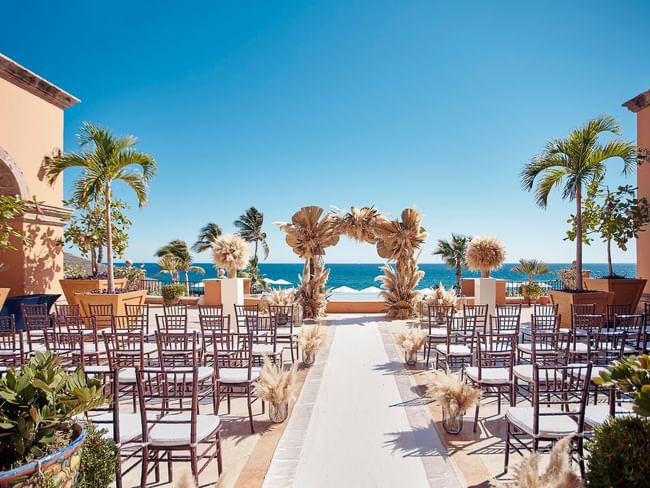 Plazuela, montaje para bodas al aire libre con sillas dispuestas con prolijidad frente al mar en Hacienda del Mar Los Cabos
