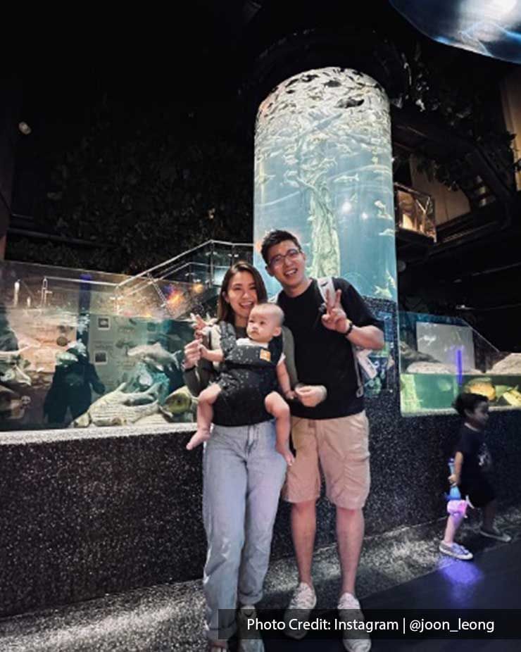 Family posing by a fish tank in Aquaria KLCC, a popular local attraction near Imperial Lexis Kuala Lumpur