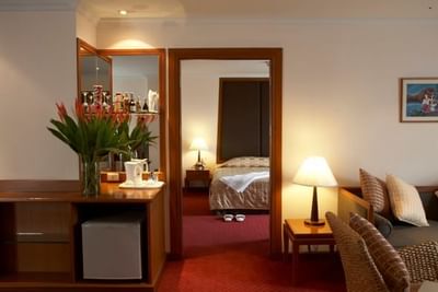 Living area with a bedroom in suite at Amora Hotel Chiang Mai