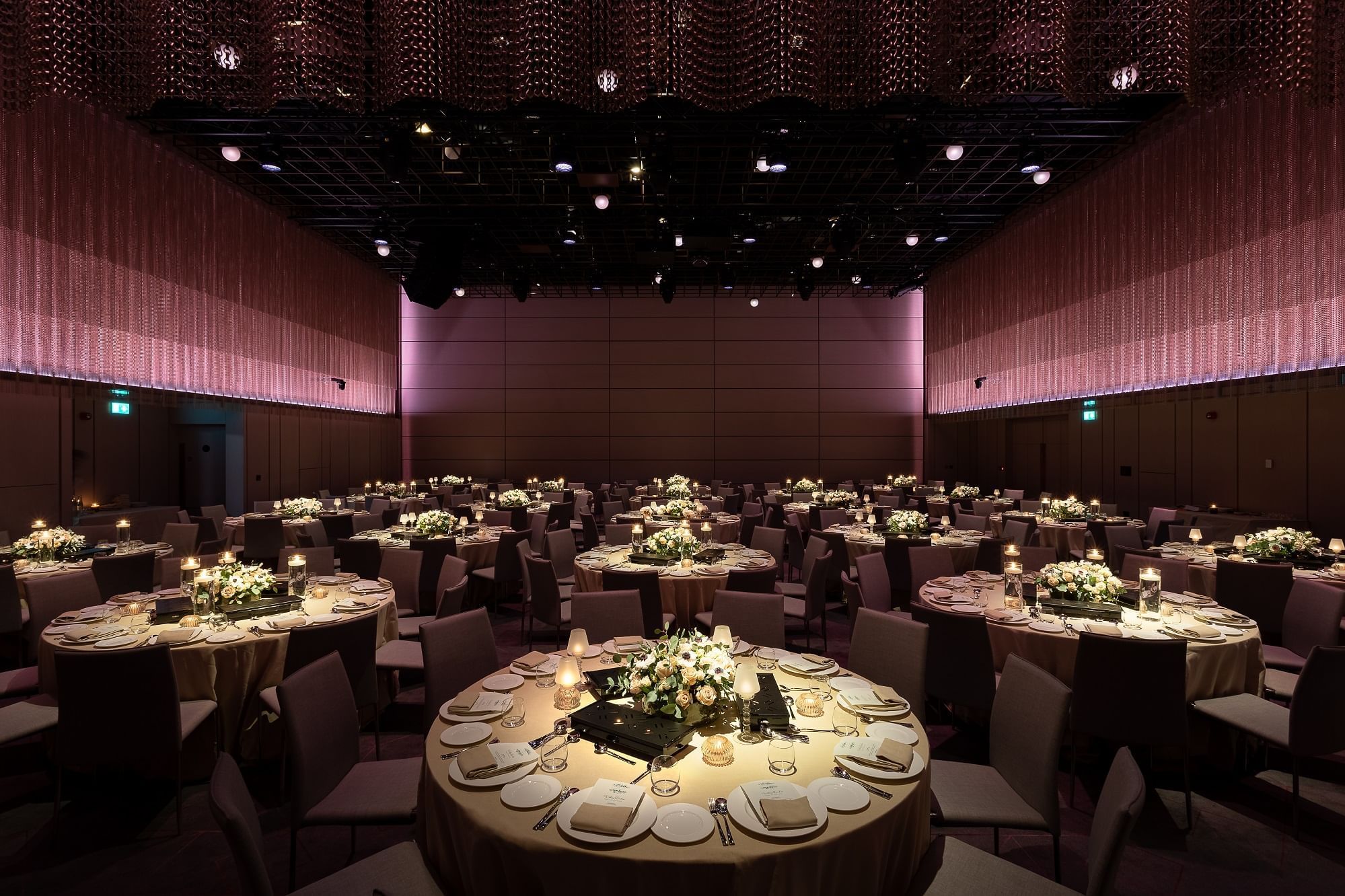 Round table arrangement with floral decors and elegant lighting for a wedding at The Londoner Hotel