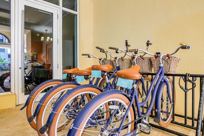 Row of blue rental bicycles with wicker baskets and tan seats parked near the entry of The Atlantic Hotel & Spa