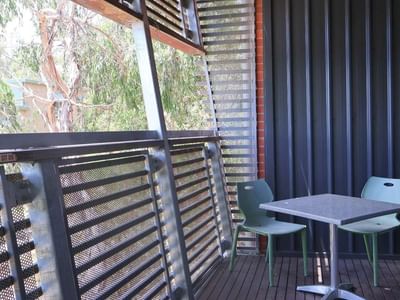 Outdoor balcony with a table and chairs at La Trobe University Hillside Apartments.