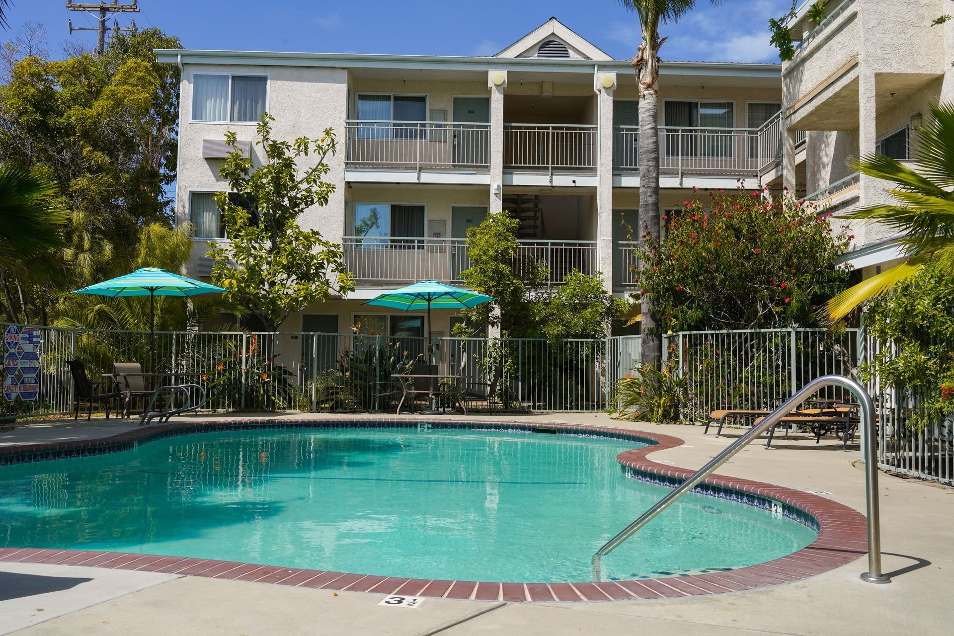 A hotel pool with a beige building in the background
