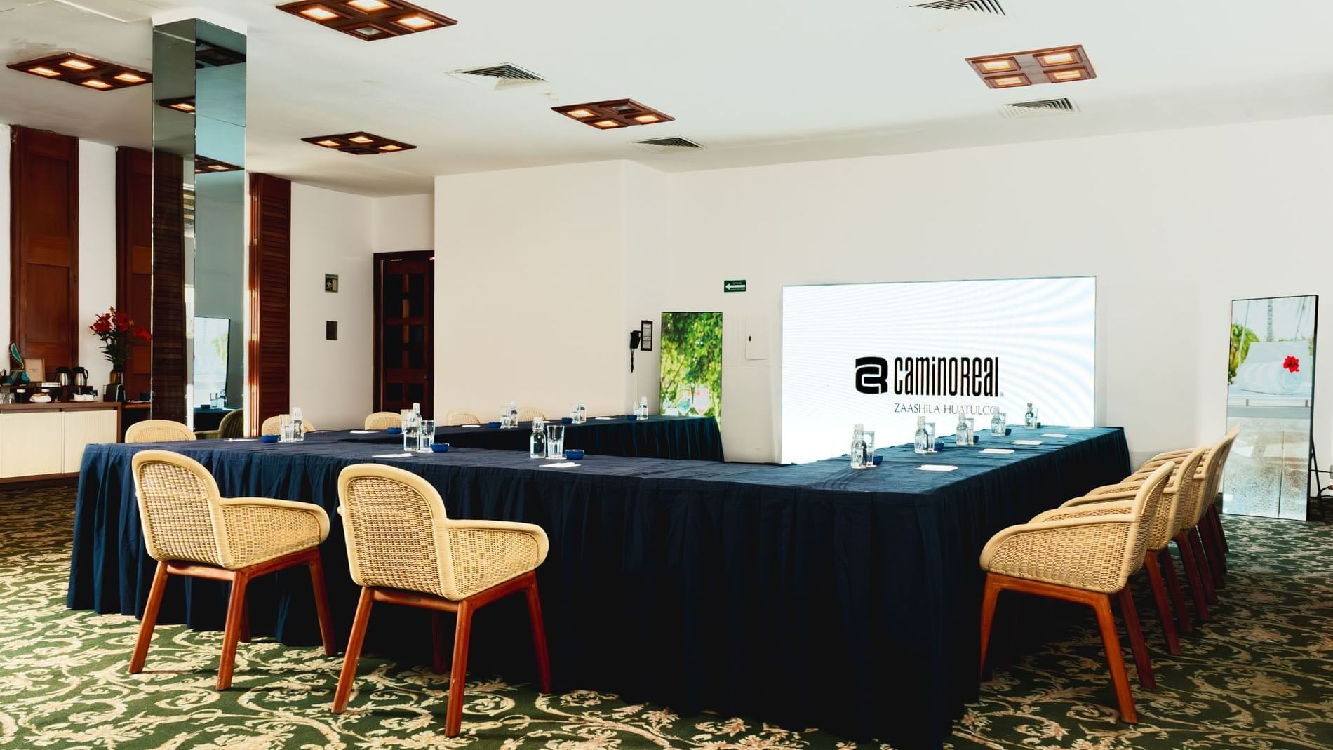 U-shaped table set-up with a projector screen and carpeted floors in Indato II at Camino Real Zaashila Huatulco