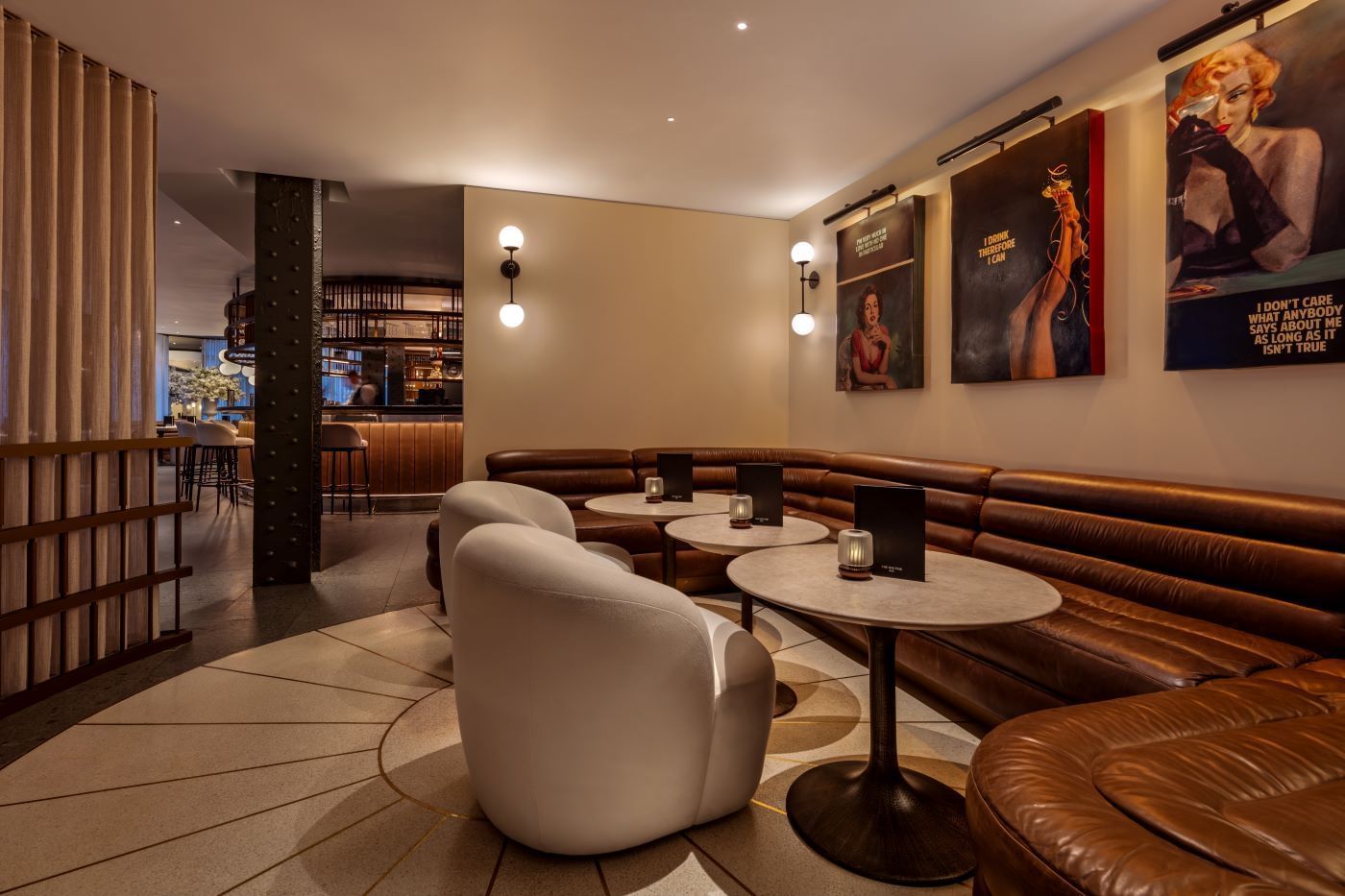 Leather seating and tables with lit candles in a stylish lounge area at The May Fair Bar