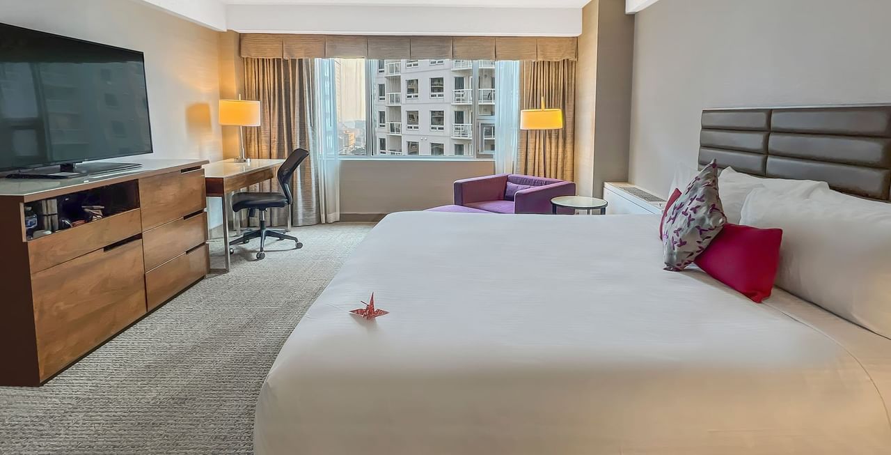 Hotel room with bed, TV, couch, work desk, and a view