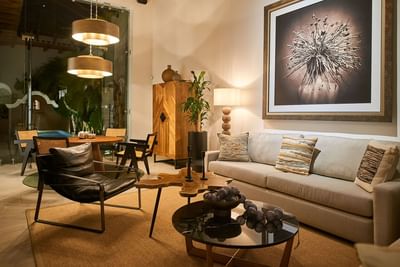 Stylish living room with a large sofa, a unique coffee table, and an oversized painting at Singular Signature Residences