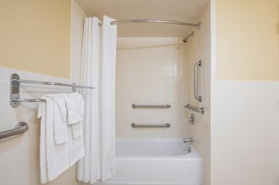 Bathroom with bathtub & towels in Standard Two Doubles Non-Smoking at Garden Executive Hotel, featuring spacious hotel rooms