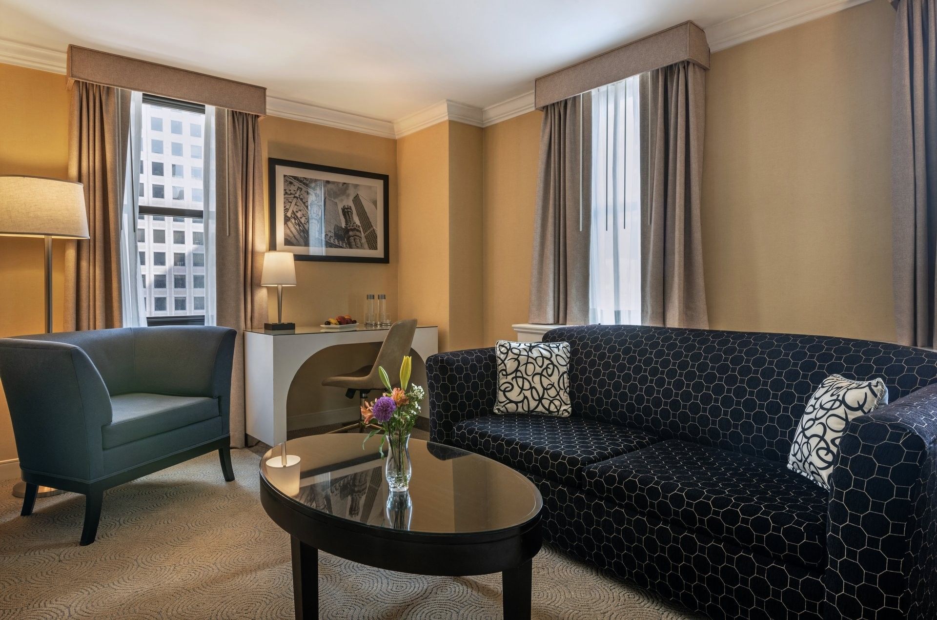 Lounge area with sofa, chair, coffee table, and flowers at Warwick Allerton Chicago - Redesign