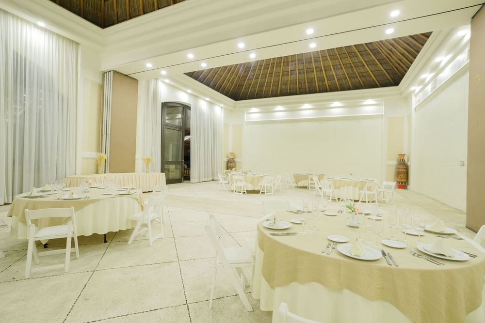 Spacious Ixtac Venue at Quinta Real Acapulco, with round tables set for a formal event under warm lights