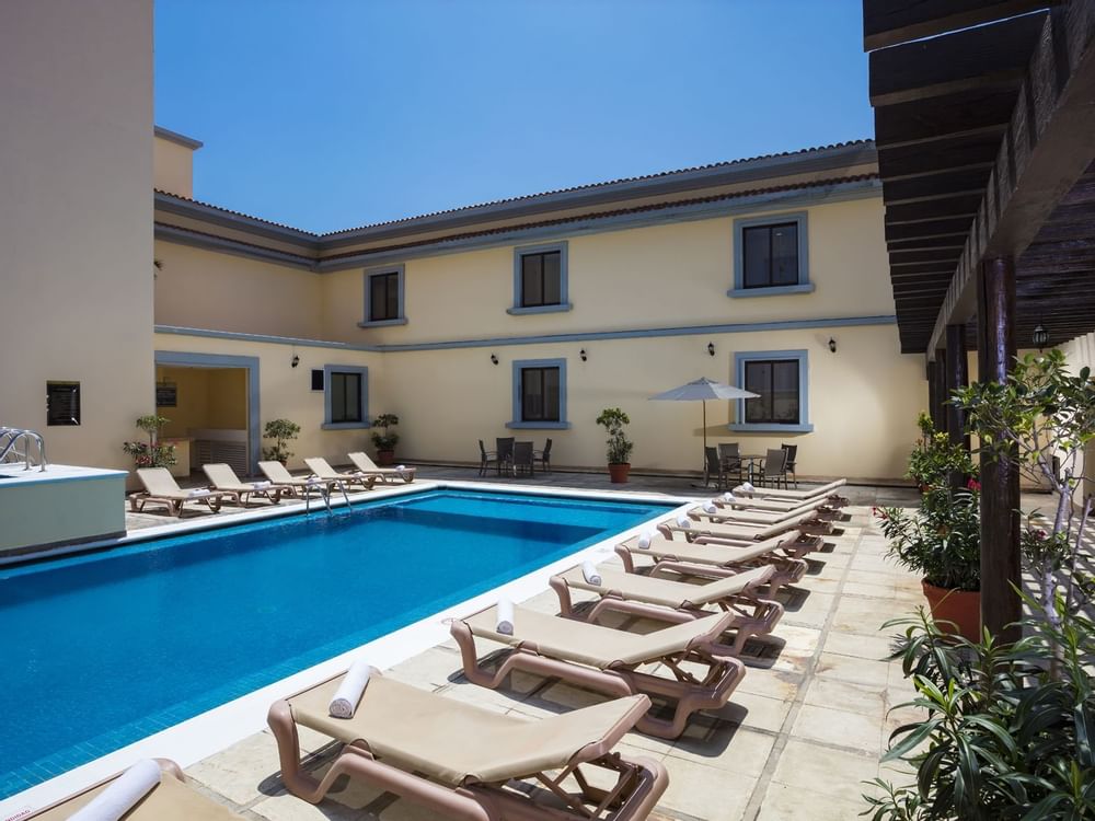 Outdoor swimming pool area with sunbeds at Fiesta Inn