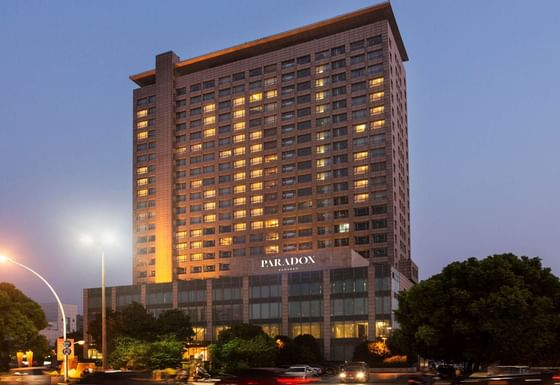 Evening view of Paradox Kunshan hotel with cars passing at Paradox Hotels and Resorts