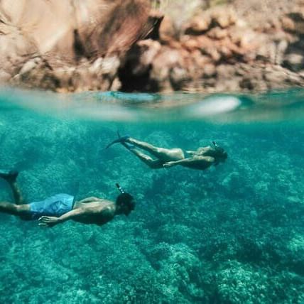 Couple scuba diving underwater near Waikiki Resort Hotel by Sono