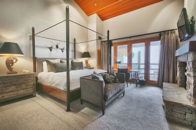 A bed & a couch facing a fireplace in a room at Stein Lodge