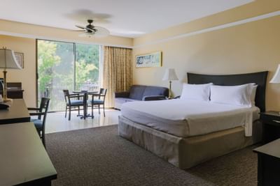 Large bed & lounge in Lagoon Room at Dinah's Garden Hotel