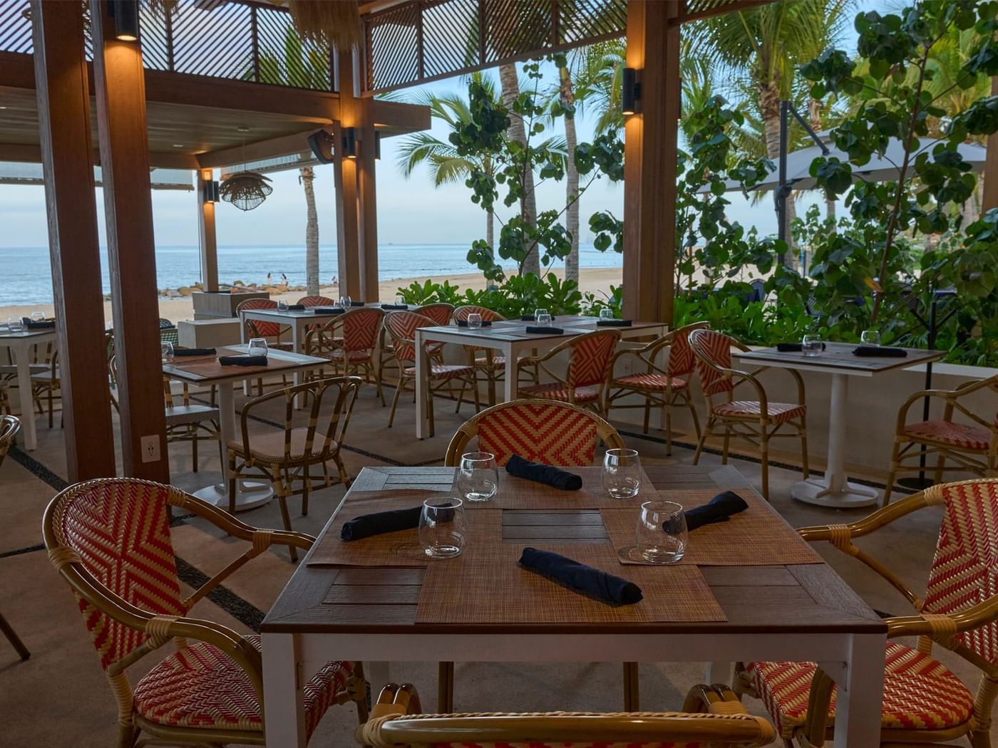 Outdoor beachfront restaurant at Fiesta Americana, with tables set for dining and a beautiful ocean view