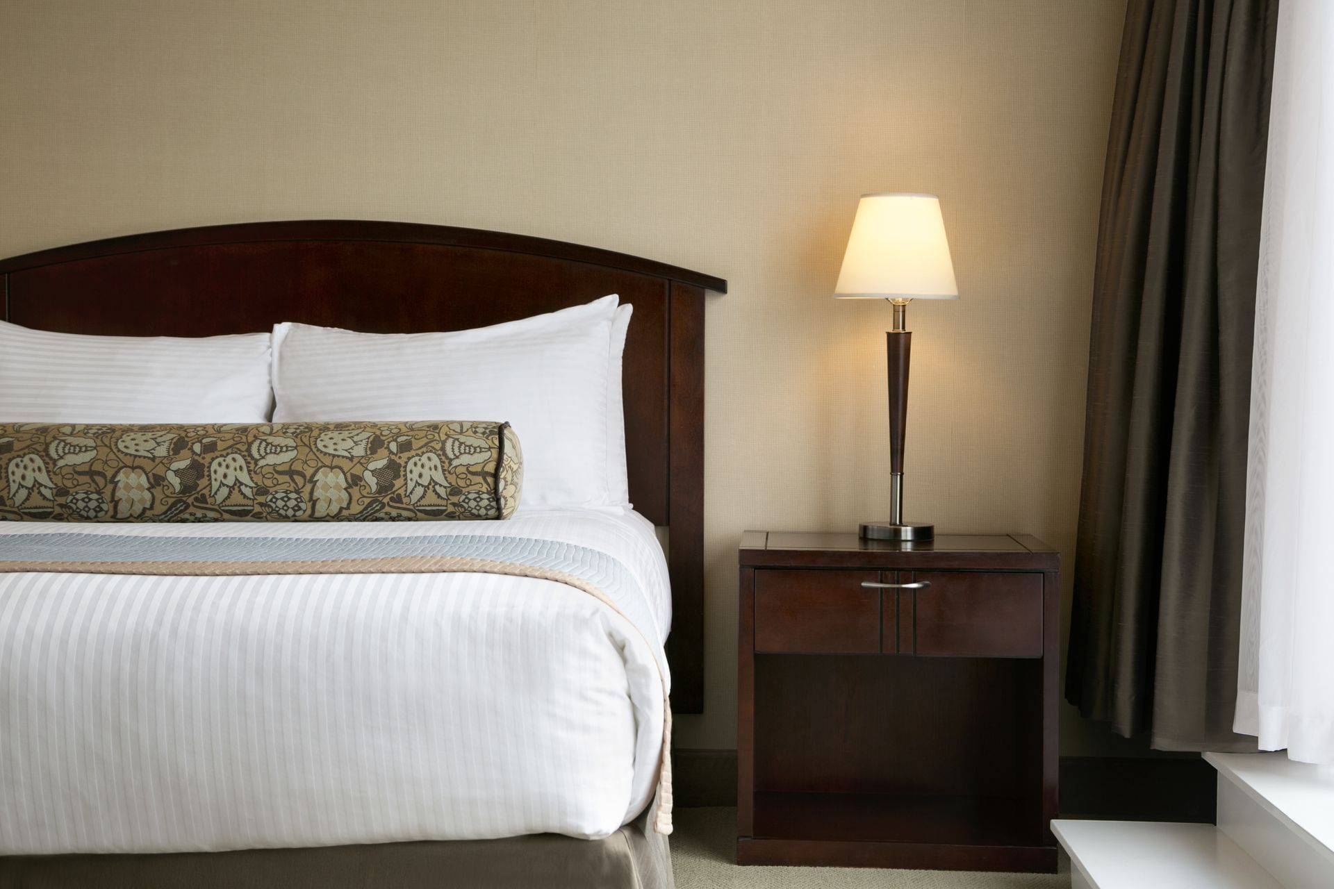 Bed next to lamp in hotel room