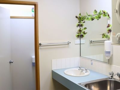 Bathroom with sink, mirror, washing machine, and separate shower at La Trobe University - Terraces.