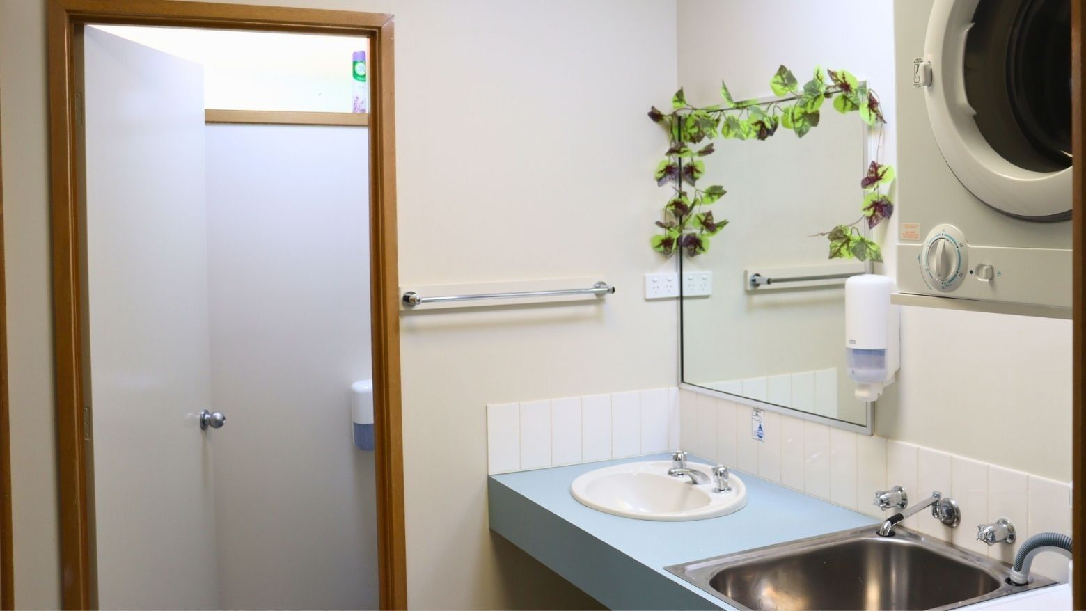 Bathroom with sink, mirror, washing machine, and separate shower at La Trobe University - Terraces.