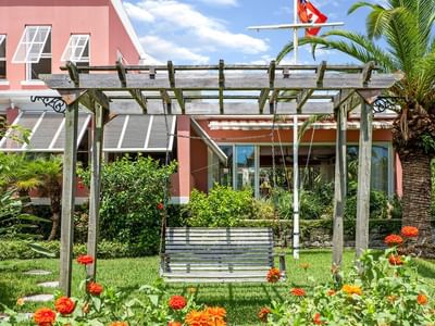 A swing surrounded by colorful flowers in a garden at Royal Palms Hotel