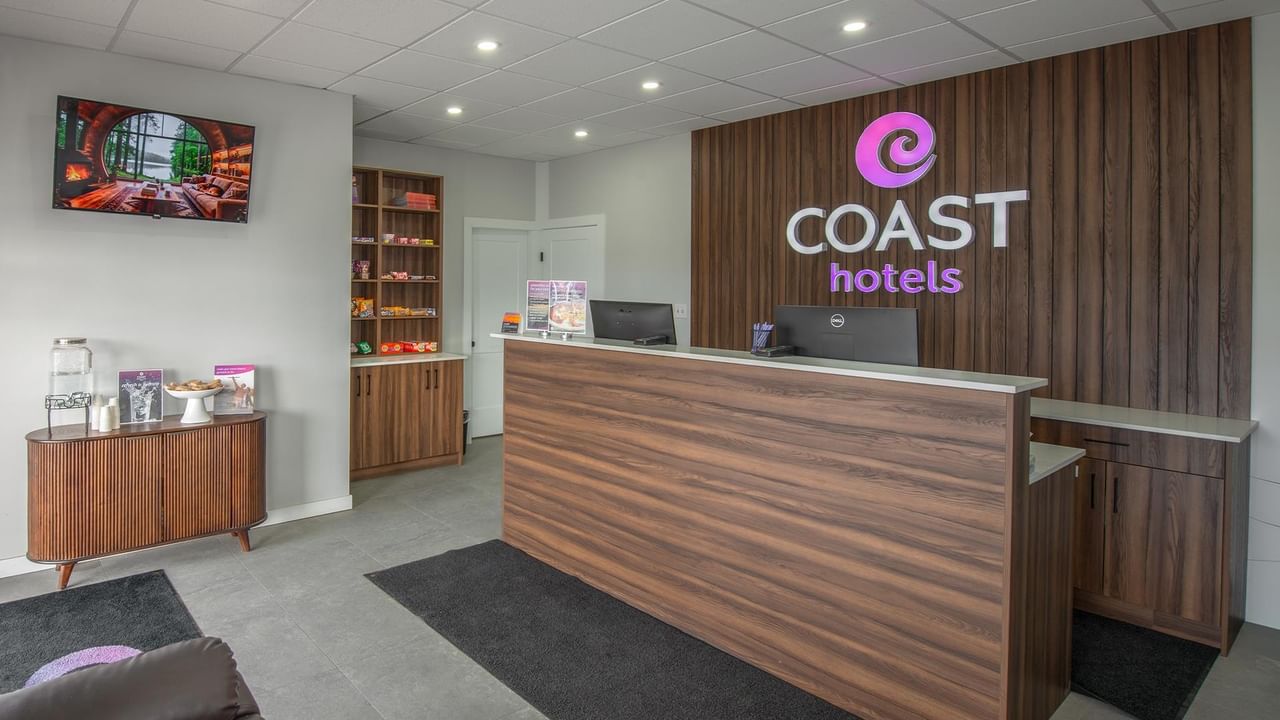 Coast Dawson Creek Hotel lobby with wooden reception desk and branded signage.