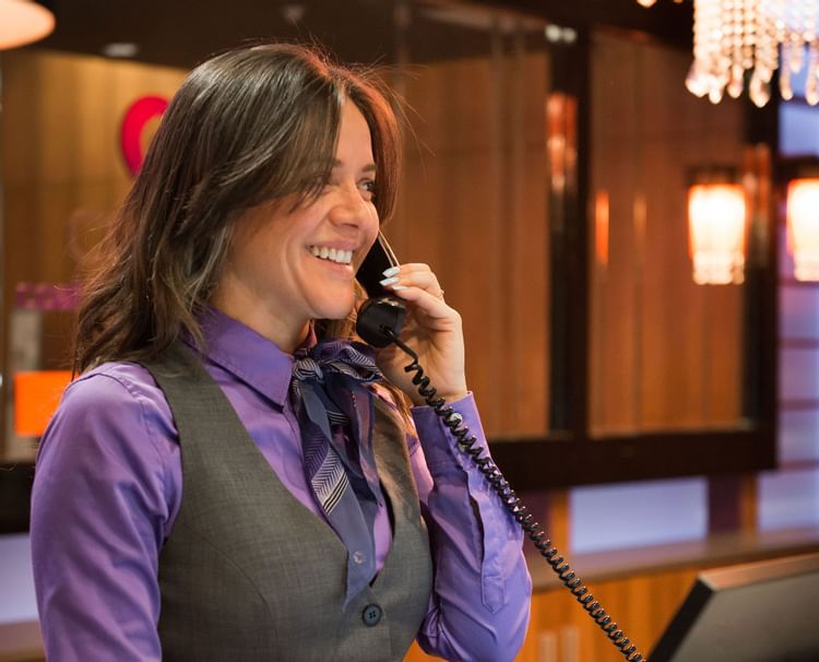 Hotel concierge smiling and speaking on phone