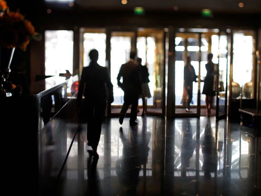 Des personnes se promenant dans le salon du hall du Warwick Paris Champs-Élysées