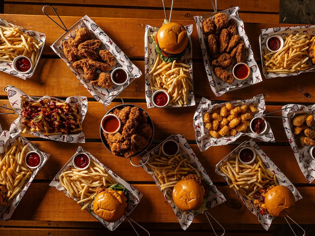 Spread featuring an array of loaded burgers & golden fries in KG Sport Bar at Mercure Brisbane King George Square