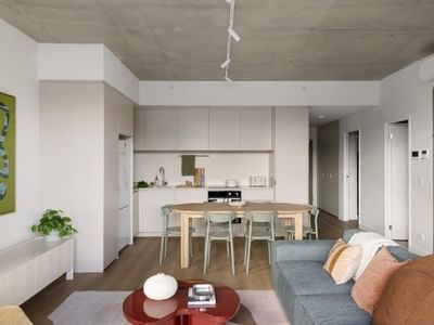 Living room with a blue couch, dining area, and kitchen at Swift Walk.